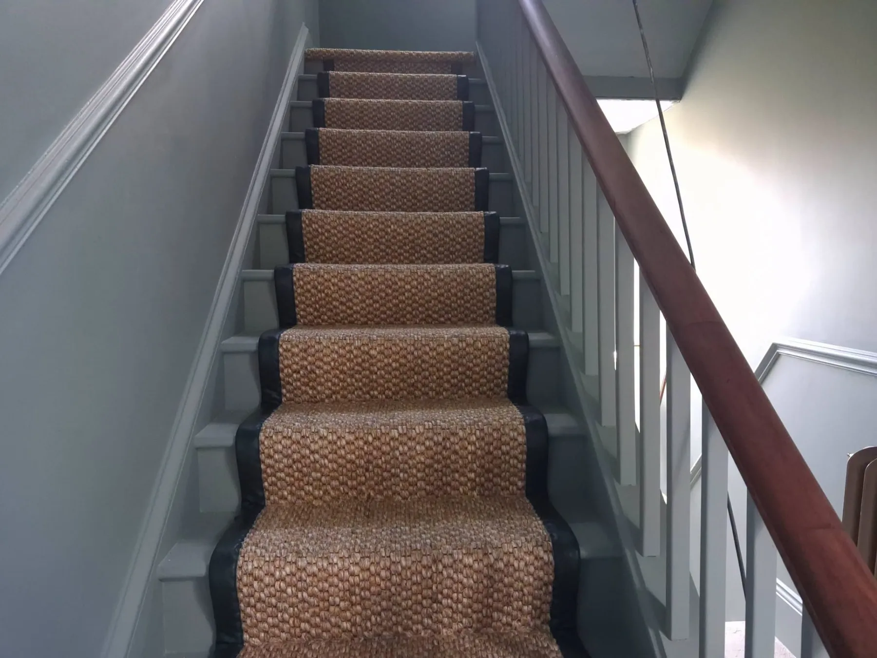 Natural stair runner fitted neatly across a painted staircase
